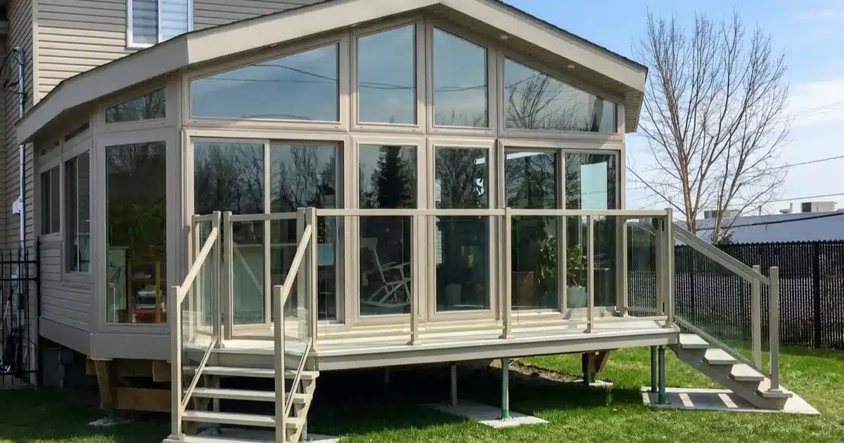 Insulated glass sunroom attached to a GTA home with stairs and glass railings