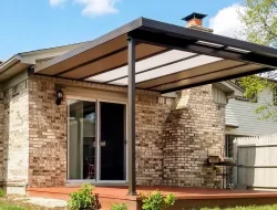 Black hybrid patio cover with acrylic and insulated panels over a suburban backyard deck
