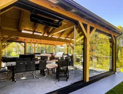 Novasun Panoramic glass panels stacked open around a timber-framed patio