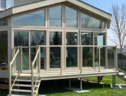 Insulated glass sunroom attached to a GTA home with stairs and glass railings